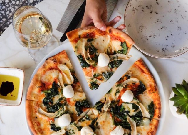 Thin pizza with basil and fresh mozzarella chunks at our Birmingham hotel