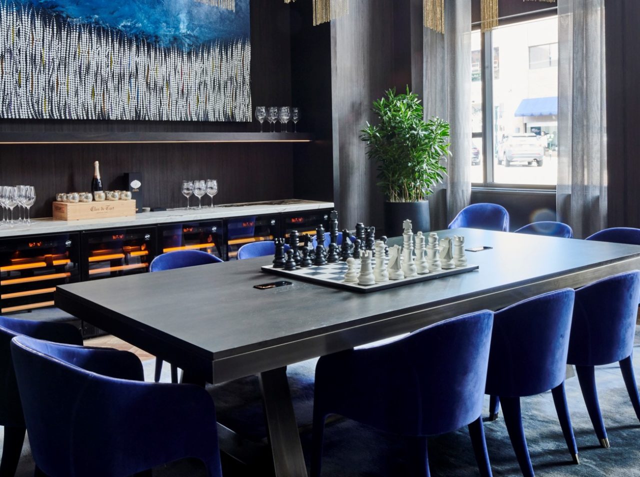 Elegant table with blue chairs set up with a chess set at our new hotel Birmingham, MI