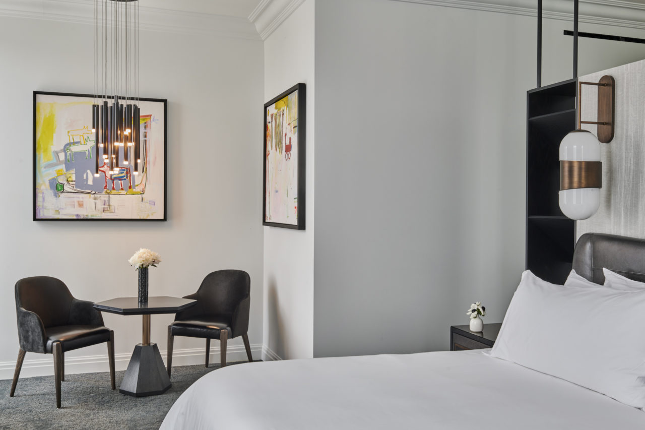 Boutique Birmingham hotel room with a bed, table, and artwork