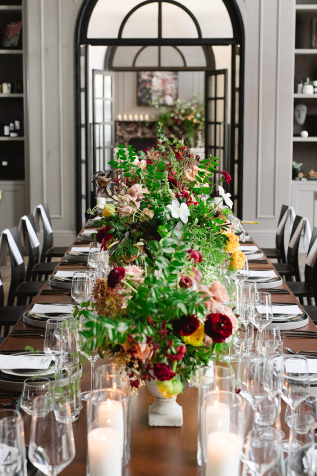 Large table with beautiful centerpieces down the line and set up for a sit down meal at our hotel venue near Detroit, MI